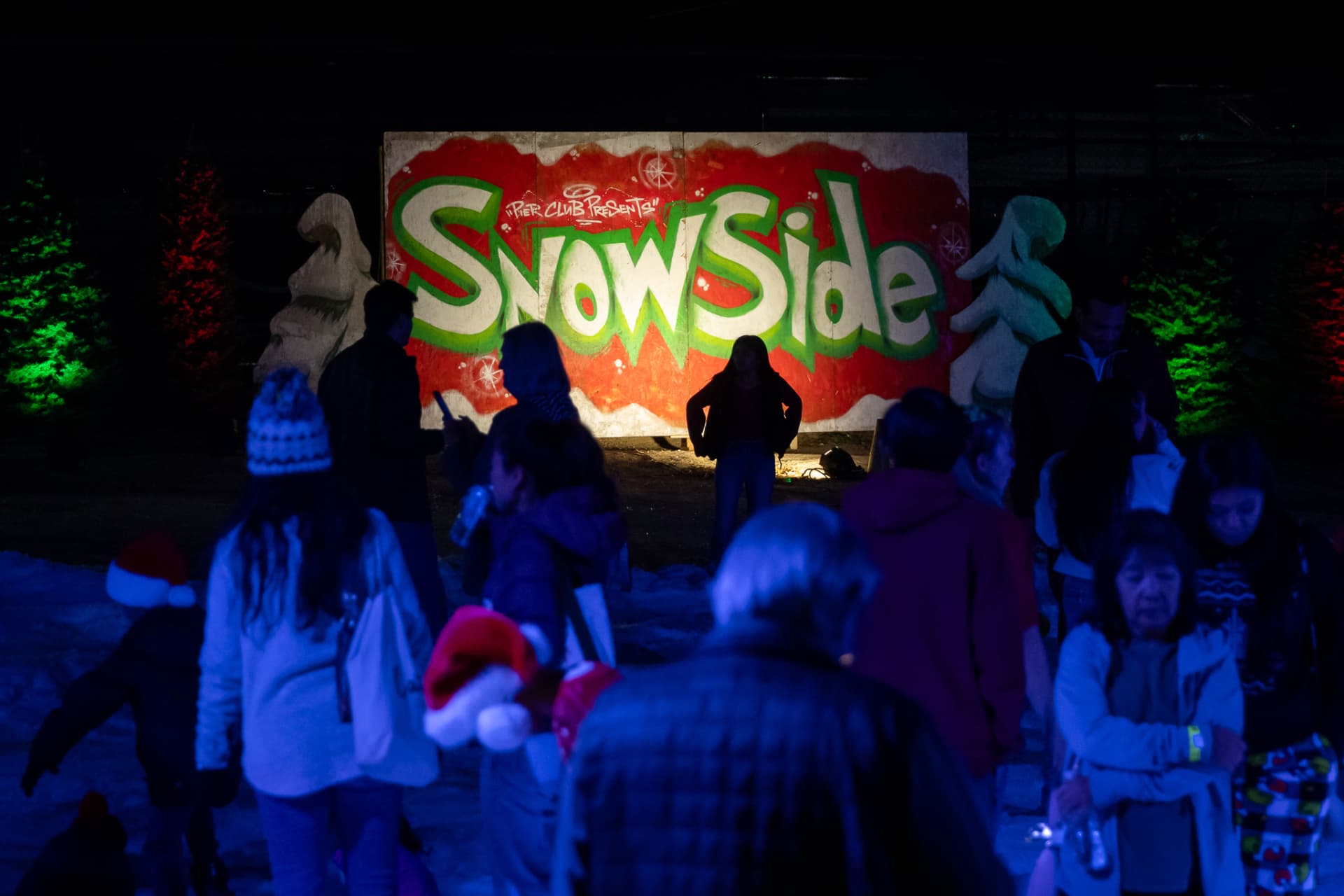 Guests gathered by the painted SnowSide mural in the snow